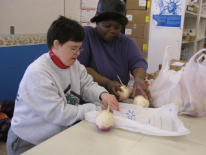 Noble participant, Angie, bagging groceries while volunteering at a local food bank