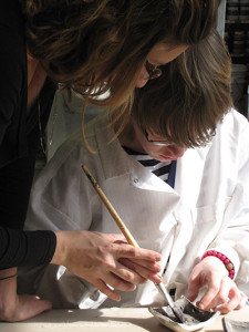 Noble participant receives help painting a clay dish during Behavioral Therapy session.