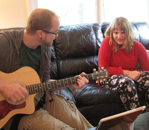 Cassidy happily singing while Noble therapist plays guitar.