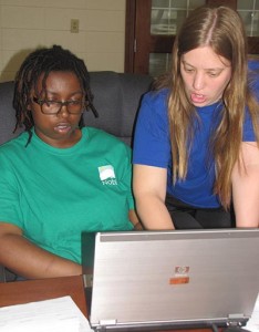 Participant using a laptop getting help from a Noble employee.