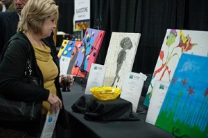 Woman admiring artwork at Evening in the Garden auction