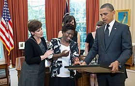 Lois Curtis presenting a piece of her art to President Obama