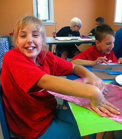 Smiling Noble camper finger painting