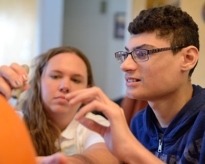 Noble participant, Jay, carving a pumpkin during Recreational Therapy session.