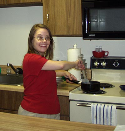 Mollie at home cooking something on the stove.